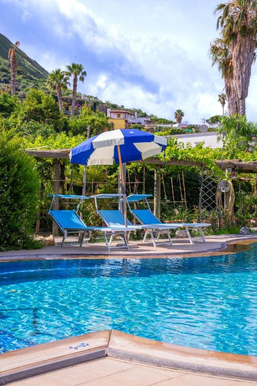 a pool with two chairs and an umbrella at Residence Parco Gioconda in Forio d'Ischia