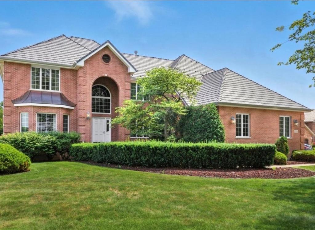 a brick house with a landscaped yard at AEQ Luxury House 1 in Orland Park