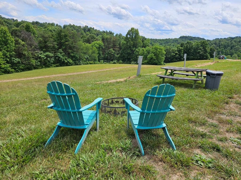 two blue chairs and a picnic table in a field at Hocking Hills Store Campsite #4 in Logan