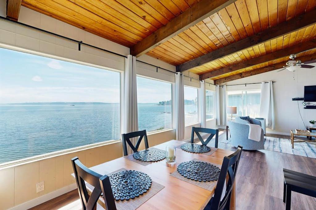 a dining room with a table and a view of the ocean at Rockaway Beach View in Port Blakely