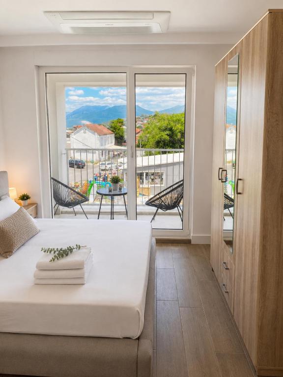 a bedroom with a bed and a balcony with a view at Our story Apartment in Milovići