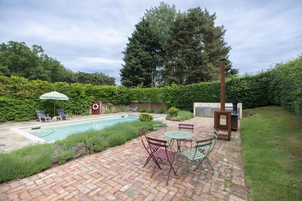 a patio with a table and chairs next to a pool at 3 Bed in Ringsfield oc-m33329 in Wingfield