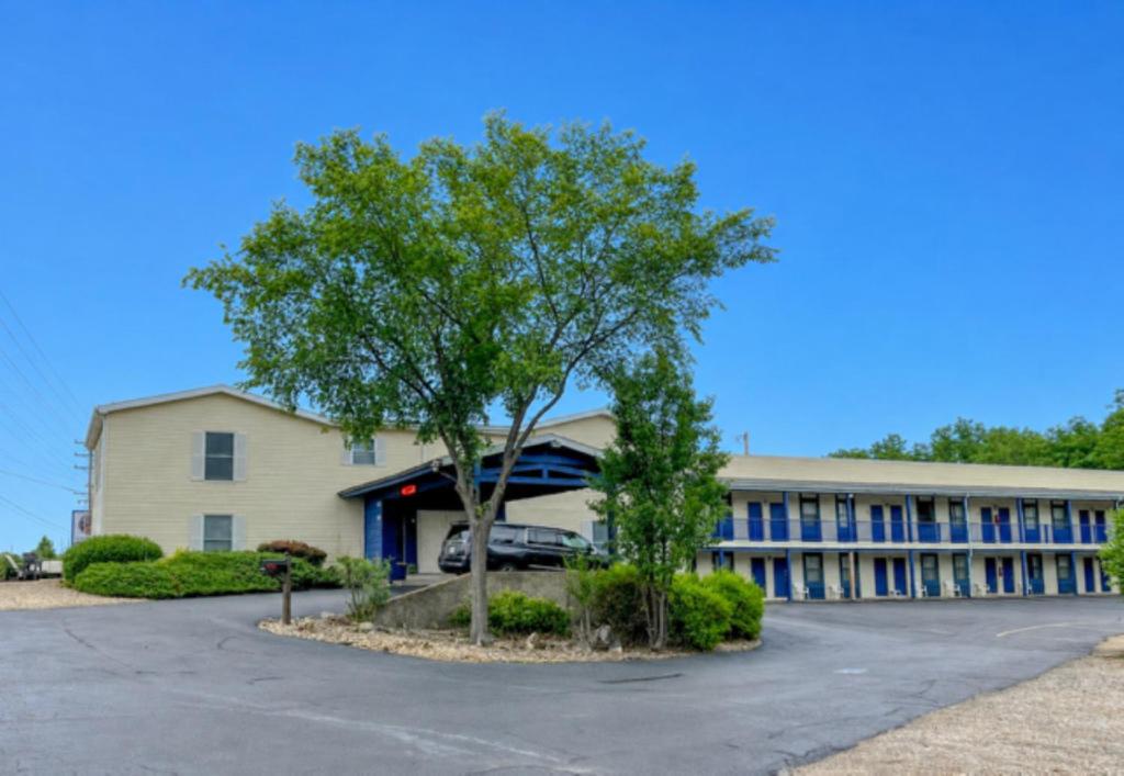 a large building with a tree in front of it at The No Wake Inn - Osage Beach in Osage Beach