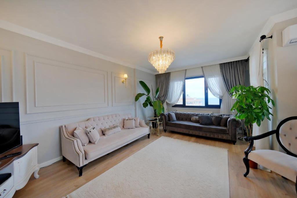a living room with a white couch and a tv at Zumra's White Houses in Trabzon