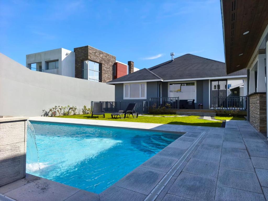 a swimming pool in front of a house at Incense in Água de Alto