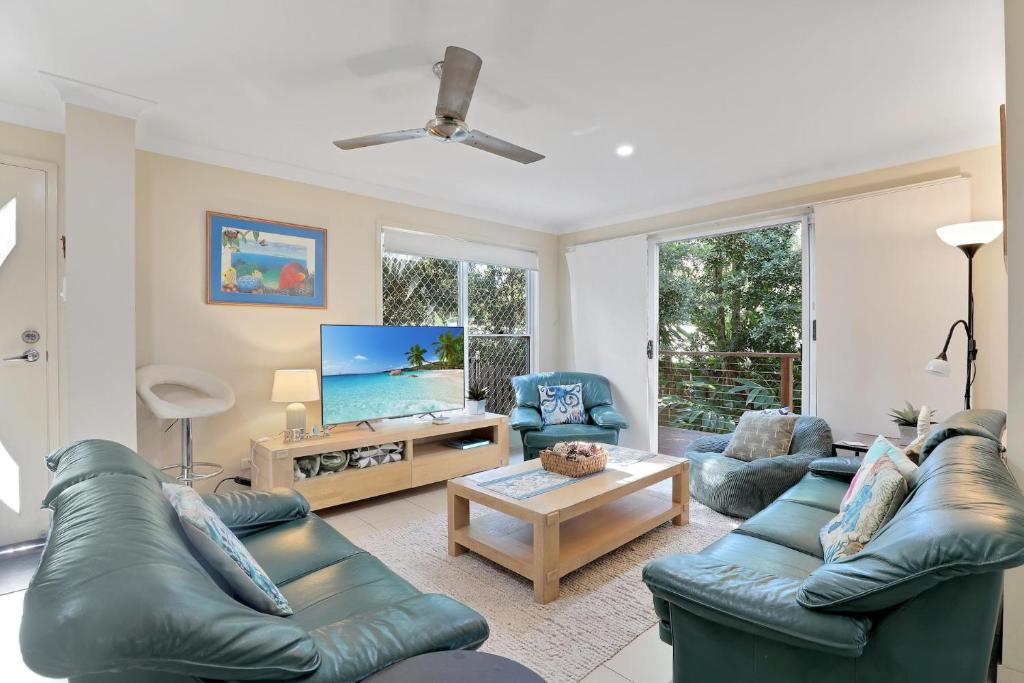 a living room with two couches and a tv at Flip Flop Inn in Amity Point