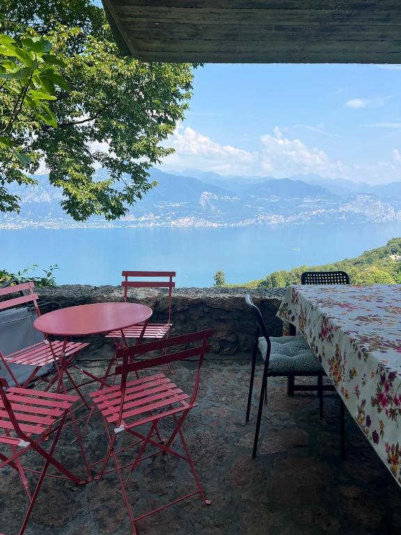 a table and chairs with a view of the water at Villa Franca San Zeno in San Zeno di Montagna