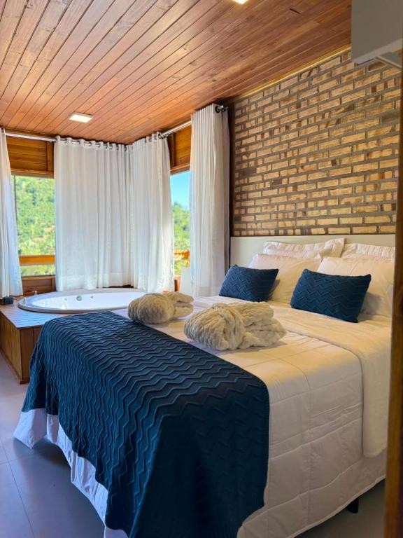 a bedroom with two beds and a large window at Chalé Saúde in Venda Nova do Imigrante