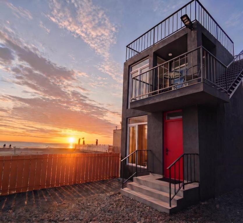 a house with a red door on the beach at Trio Villas Retreat in Grigoleti