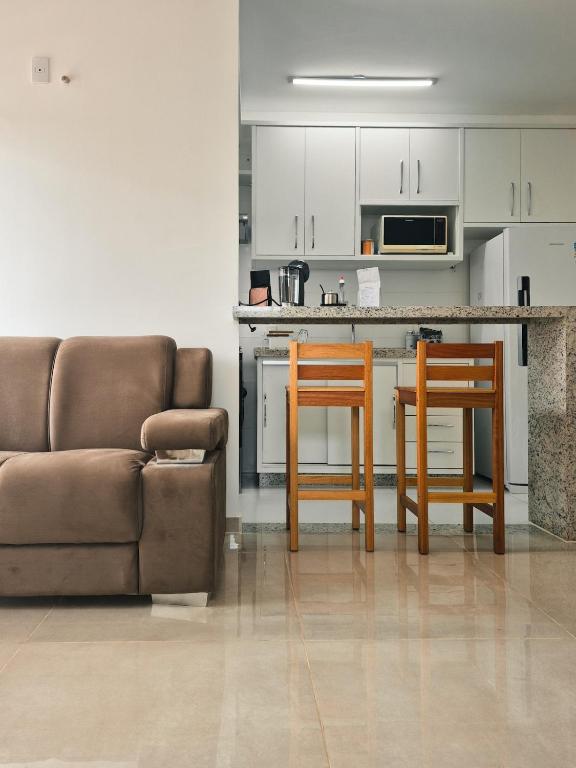 a living room with a couch and a kitchen at Bela Vista Por do Sol in Espirito Santo Do Pinhal