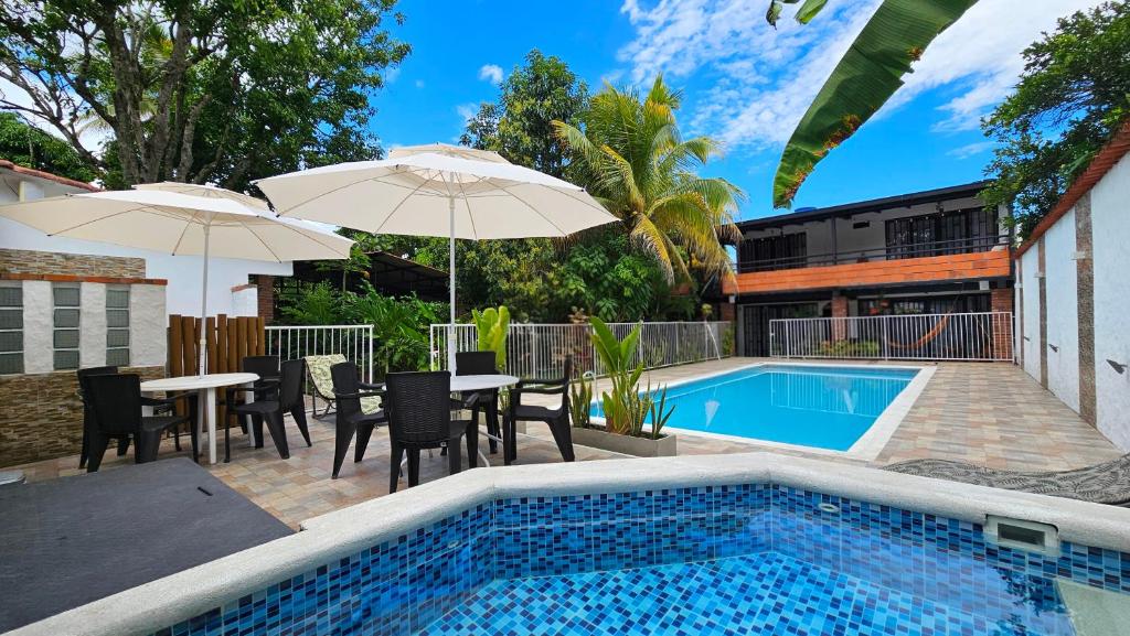 a pool with tables and chairs and umbrellas next to at B&B Villa CALASAN in Garzón