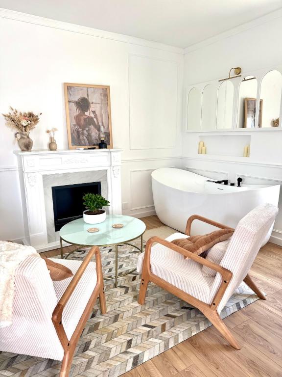 a living room with a tub and a table and chairs at La Folie Blanche in Vertou