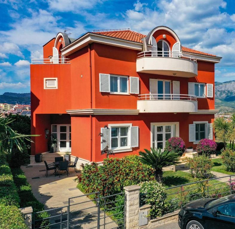 a orange house with a balcony on top of it at Apartmani Villa Biočić in Split