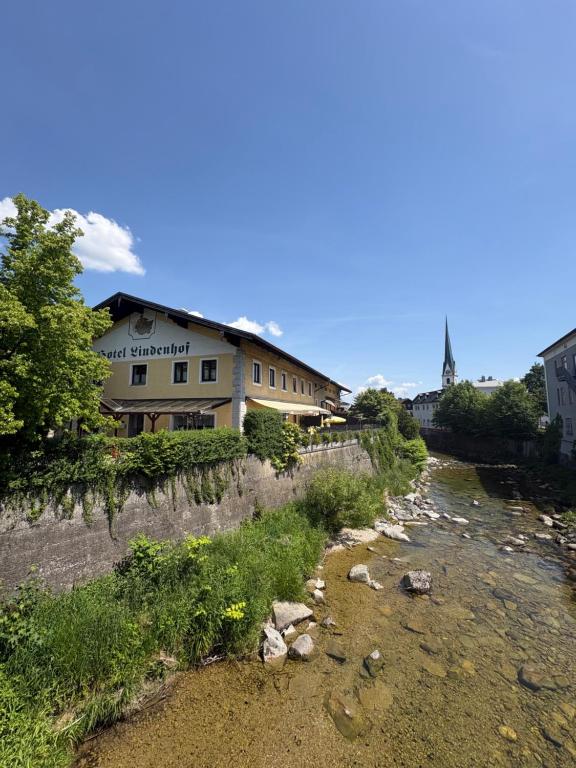 a building sitting on the side of a river at Hotel Pension Lindenhof in Prien am Chiemsee