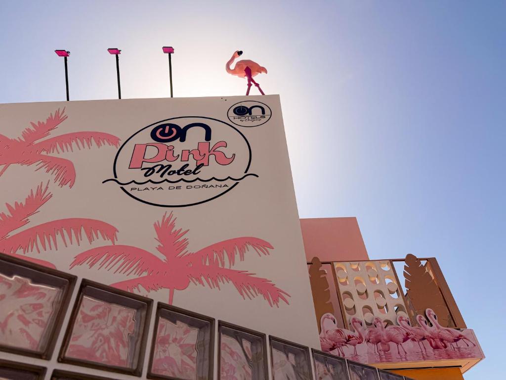 a building with a flamingo on top of it at On Pink Motel in Matalascañas