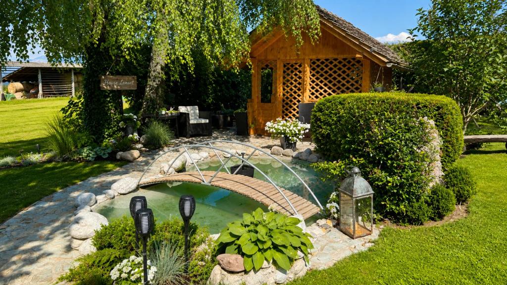 a small pond with a bridge in a yard at Apartments Ladka in Begunje na Gorenjskem