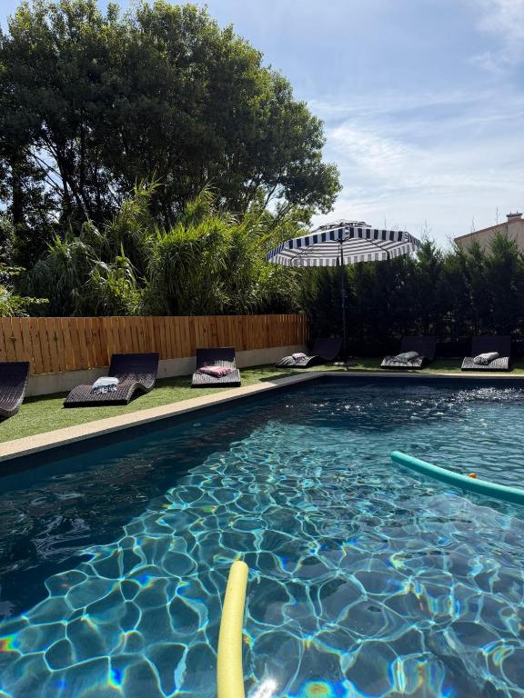 a swimming pool in a yard with chairs and trees at Azurara Guesthouse in Azurara