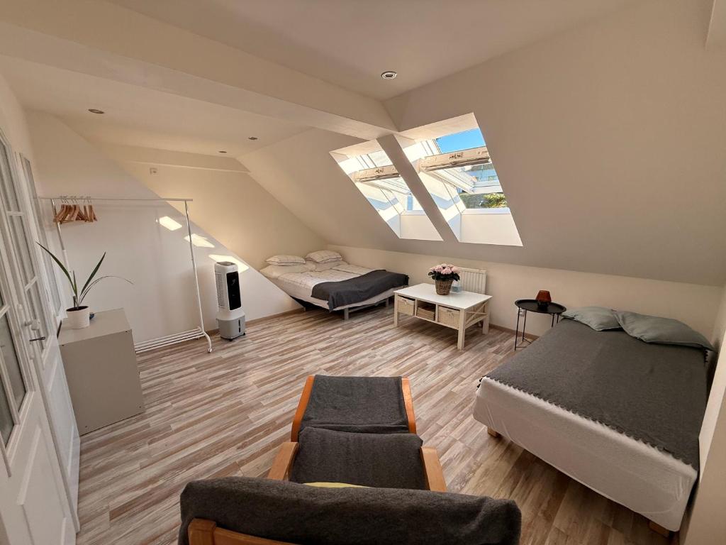 a attic room with a bed and a couch and a tv at Apartmán Bílé Karpaty in Strání