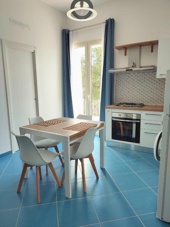 a kitchen with a table and chairs and a stove at L'Eco del Mare in Pisciotta