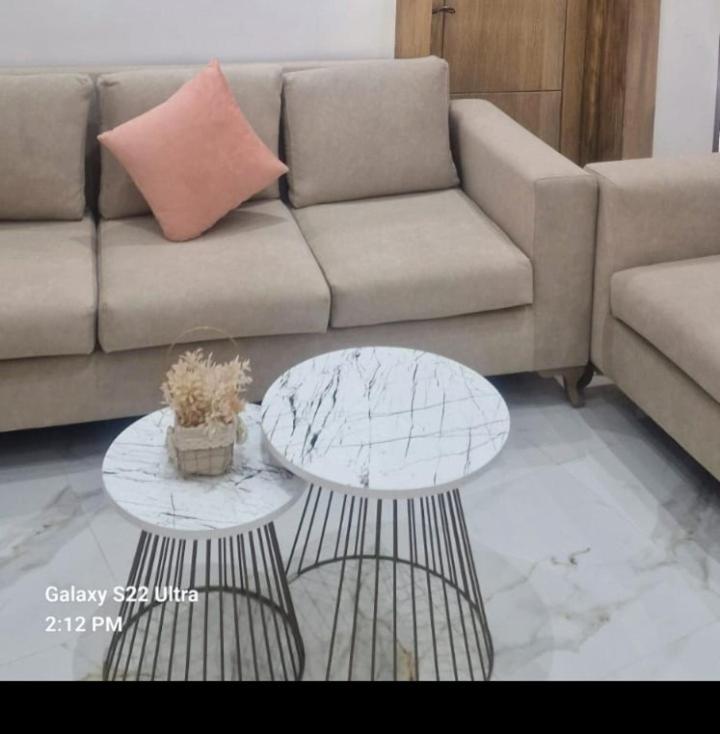 a living room with a couch and two tables at Jolie Villa à Sahloul in Sousse