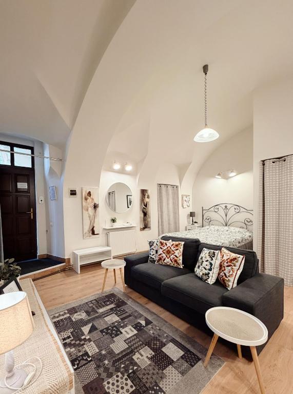a living room with a black couch and a bedroom at Center feelings studio by Alandala in Cluj-Napoca