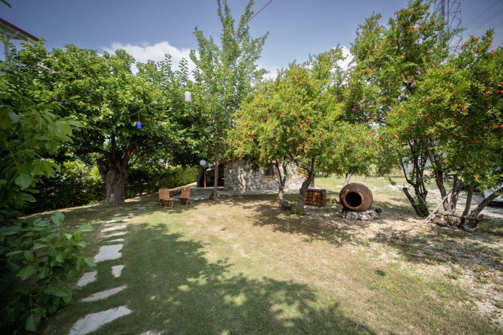 a yard with trees and a stone building at Dutlu Konak Taş Evleri in Soğucak