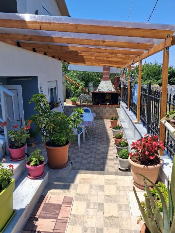 a patio with potted plants and a fireplace at Kurti Home in Agia Triada