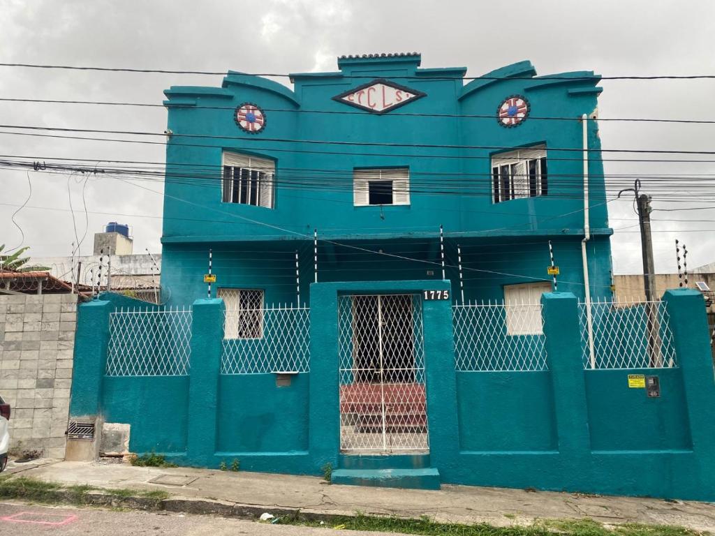 a blue building with two clocks on top of it at Pousada Cisne Branco in Natal