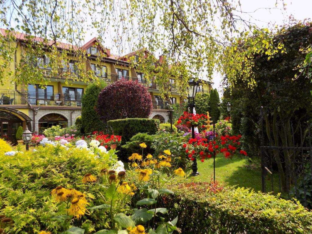 a garden with flowers in front of a building at Pensjonat Angela in Łeba