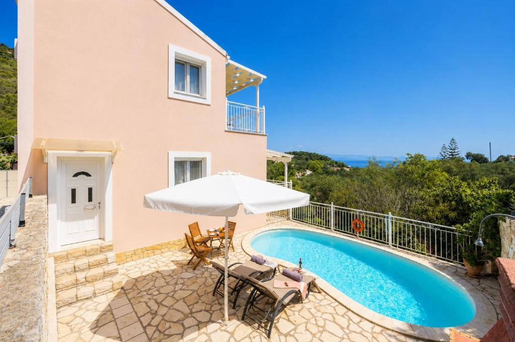 a villa with a swimming pool and an umbrella at Villa Magda Dione in Gaios