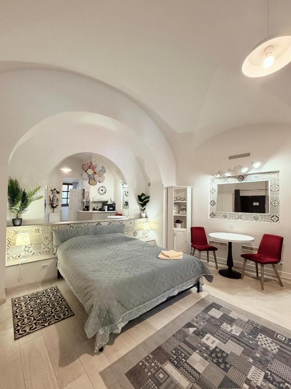 a bedroom with a bed and a table and chairs at Alandala Story in Cluj-Napoca