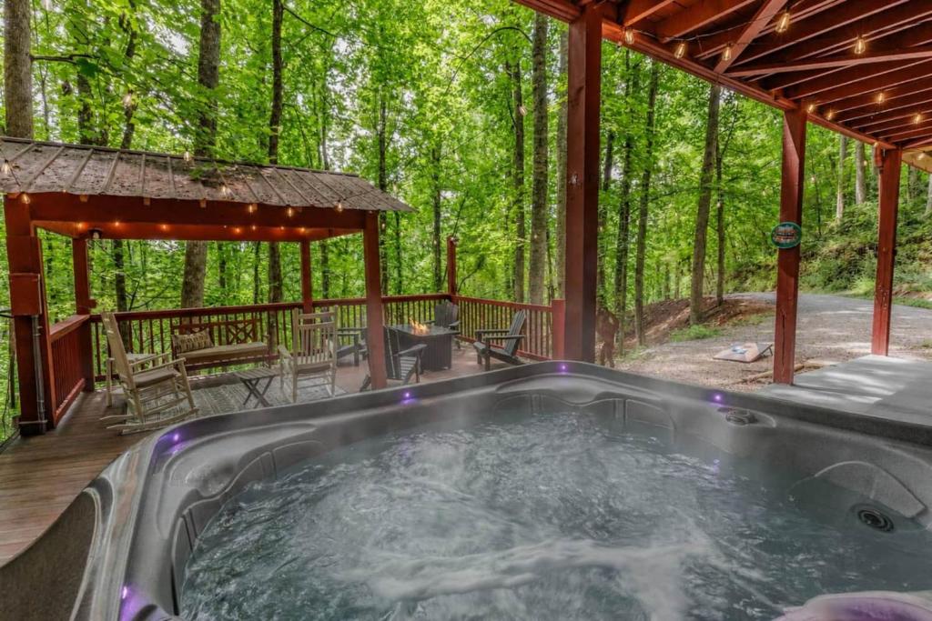a hot tub on the deck of a cabin in the woods at Re-Up Retreat King Bed, Hot Tub, Zero Pet Fees in Whittier