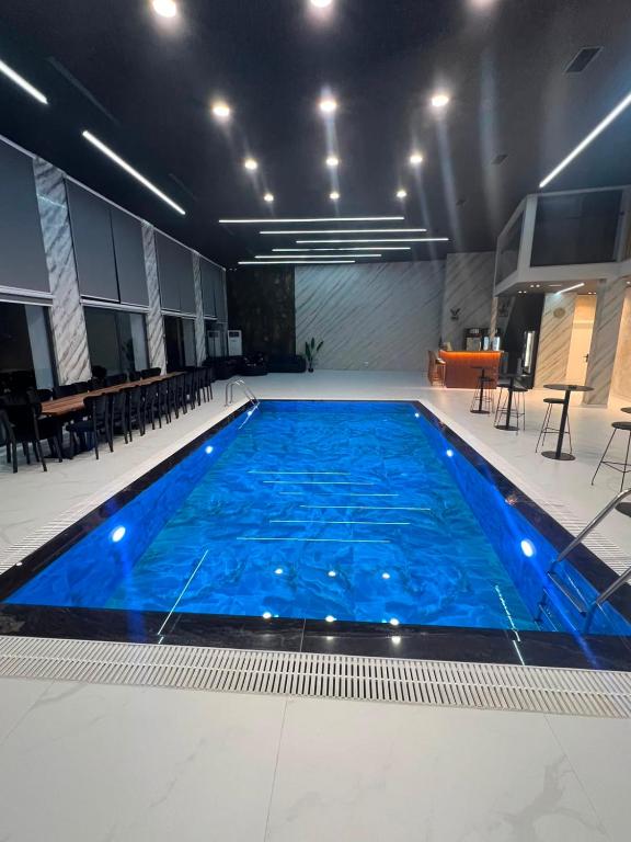 a large pool with blue water in a building at Vila Elezi 2 in Tirana