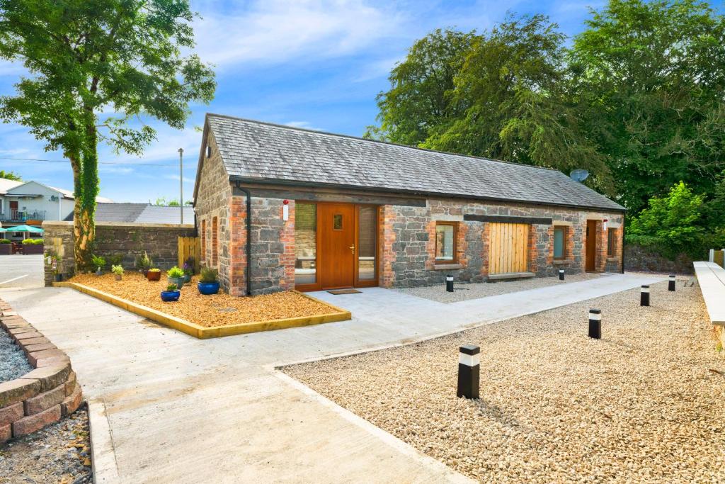 a stone house with a courtyard in front of it at Millmaster Apartment in Drumahayre