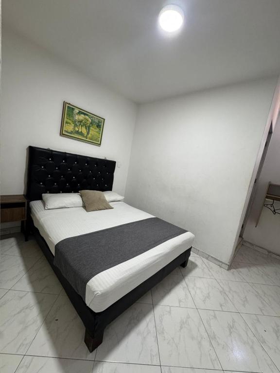 a bedroom with a bed in a white room at Hotel Imperio Real Medellin in Medellín