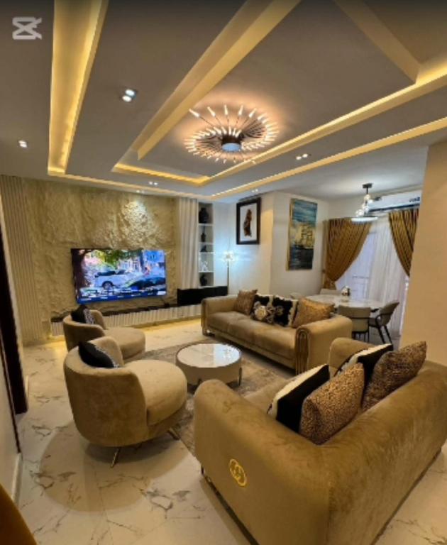 a large living room with couches and a television at De Crystal Place in Ikate