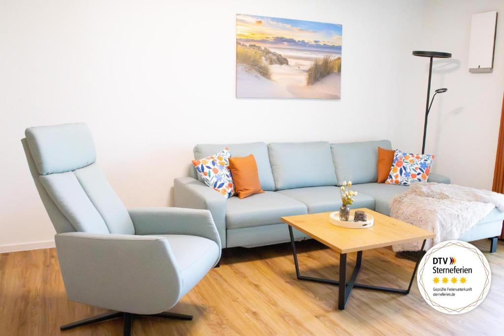 a living room with a blue couch and a table at Schöne Tiet - Küste33 26 in Tossens