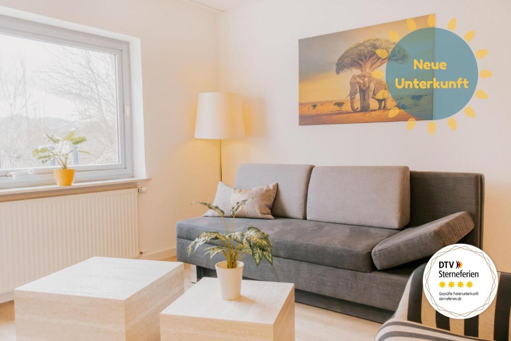 a living room with a couch and a table at Lago Edera - Talblick in Hemfurth-Edersee