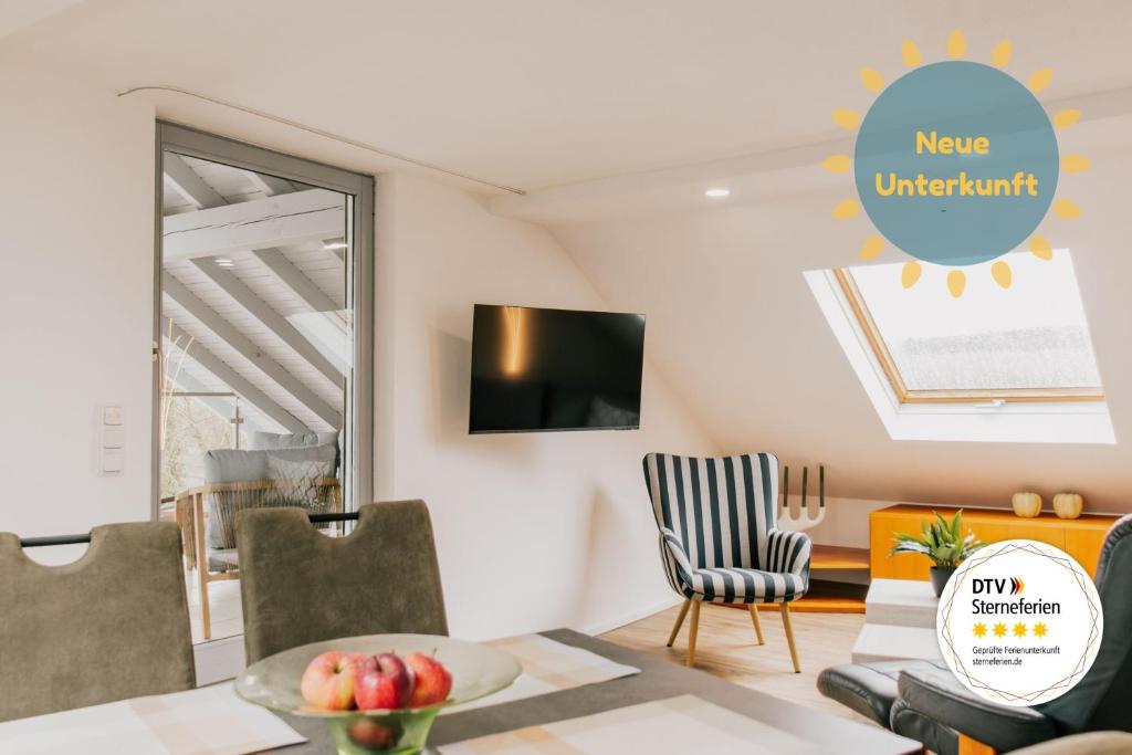 a living room with a tv and a table and chairs at Lago Edera - Seeblick in Hemfurth-Edersee