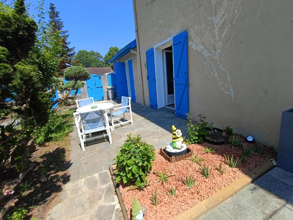 a patio with a table and chairs next to a building at Maison Éléphantaisie in Salies-de-Béarn