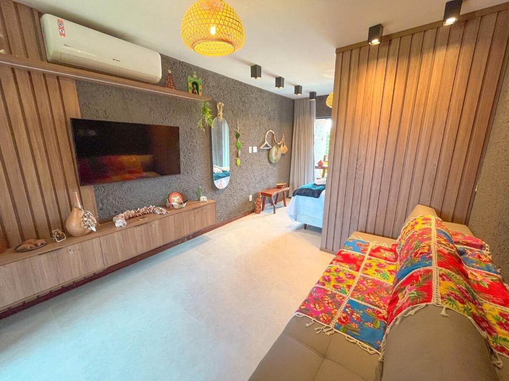 a living room with a bed and a flat screen tv at Studio Patacho Rota dos Milagres in Pôrto de Pedras