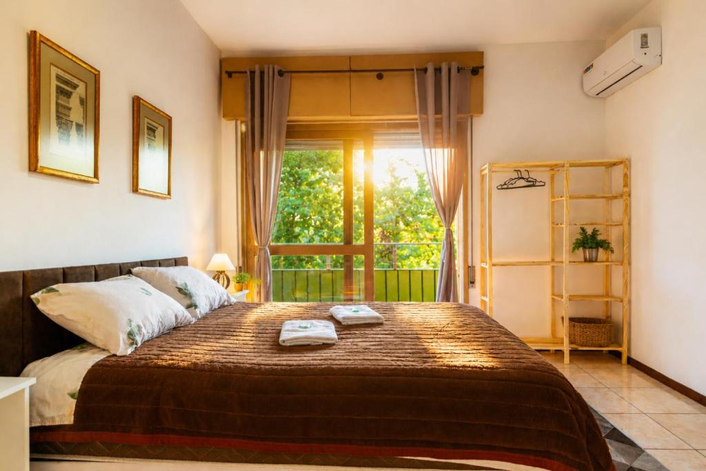 a bedroom with a bed with two towels on it at IKE Hospedagem Uruguaiana - CENTRO in Uruguaiana