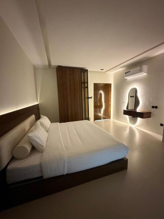 a bedroom with a large white bed in a room at شقق الحصن الفاخره in Al Baha
