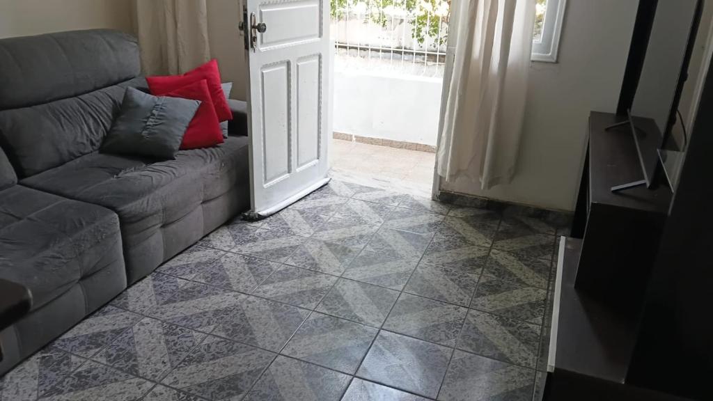 a living room with a couch and an open door at Casa da Floresta in Vitória