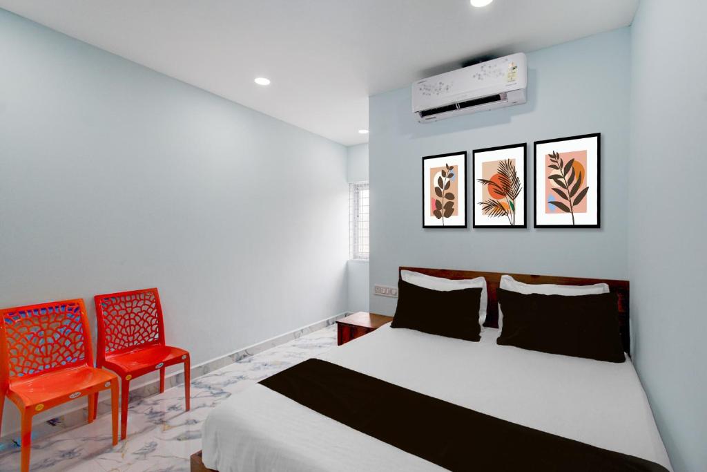 a bedroom with a bed and two red chairs at Super Hotel O MM Stay & Luxury Rooms in Hyderabad