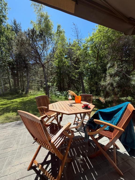 a wooden table and chairs on a patio at Poilsis Urbo Nidoje in Nida