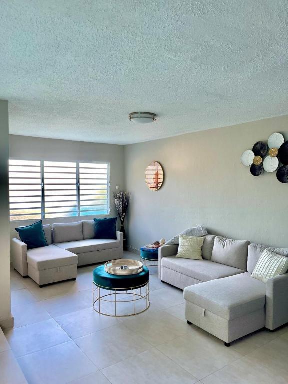 a living room with two couches and a table at Modern 4BR Oasis in Bayamón