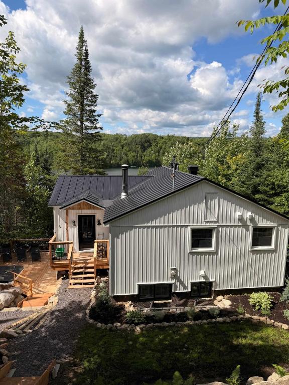 a white building with a patio and a house at Waterfront & Nature - Chalet Lac Clair in Entrelacs