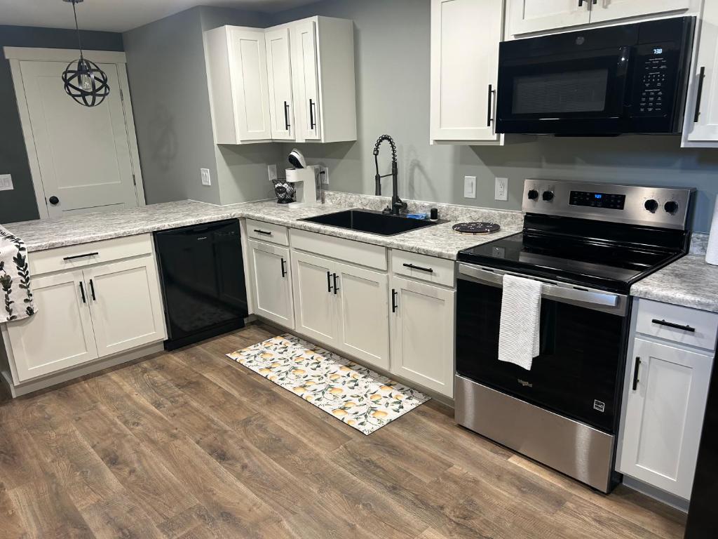 a kitchen with white cabinets and black appliances at Thirty-Six Street Retreat in Missoula