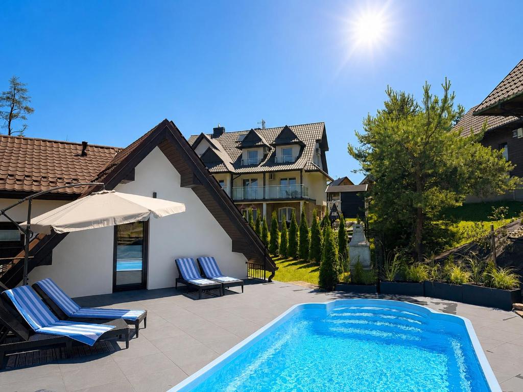 a swimming pool in front of a house at Mergen Bike & Ski Resort- basen, sauna, jacuzzi in Niedzica Zamek